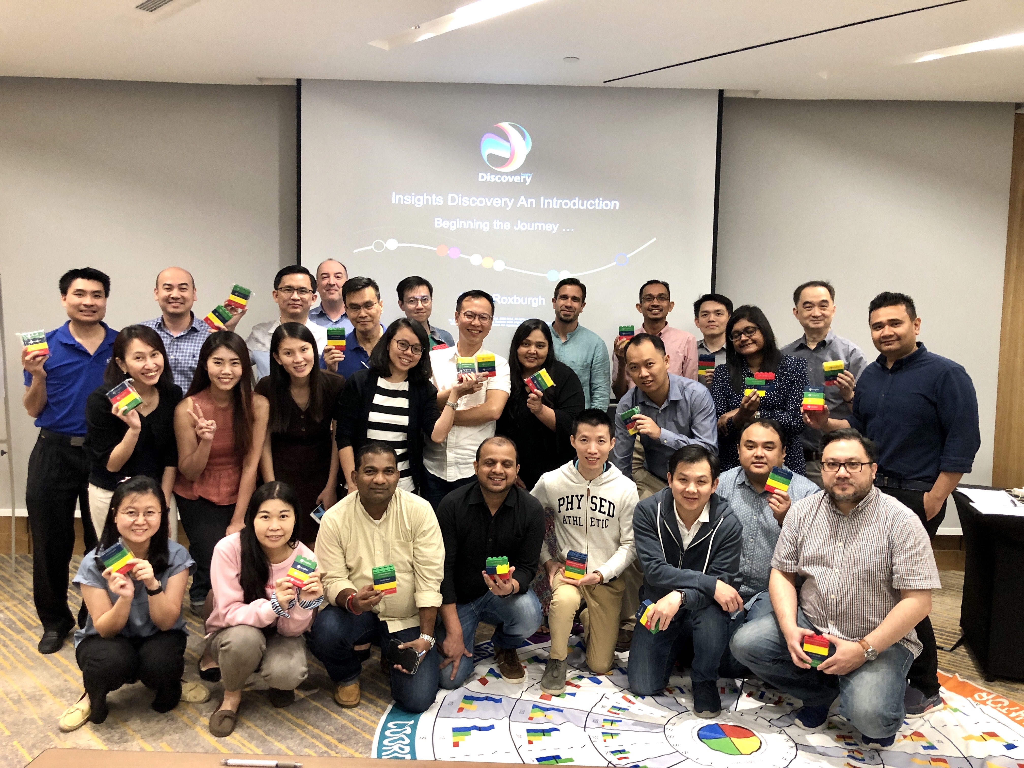 Insights Discovery workshop group holding their four-colour blocks